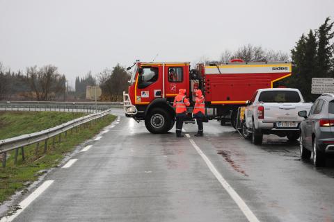 Un camion de pompiers barre une route inondée, dans l'Aude